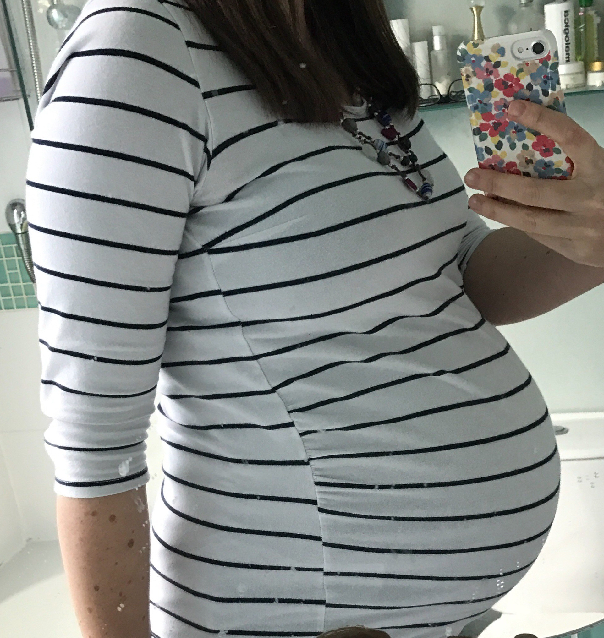 A pregnant lady's selfie of her twin bump in front of the mirror after finding out she'll be mum to three boys